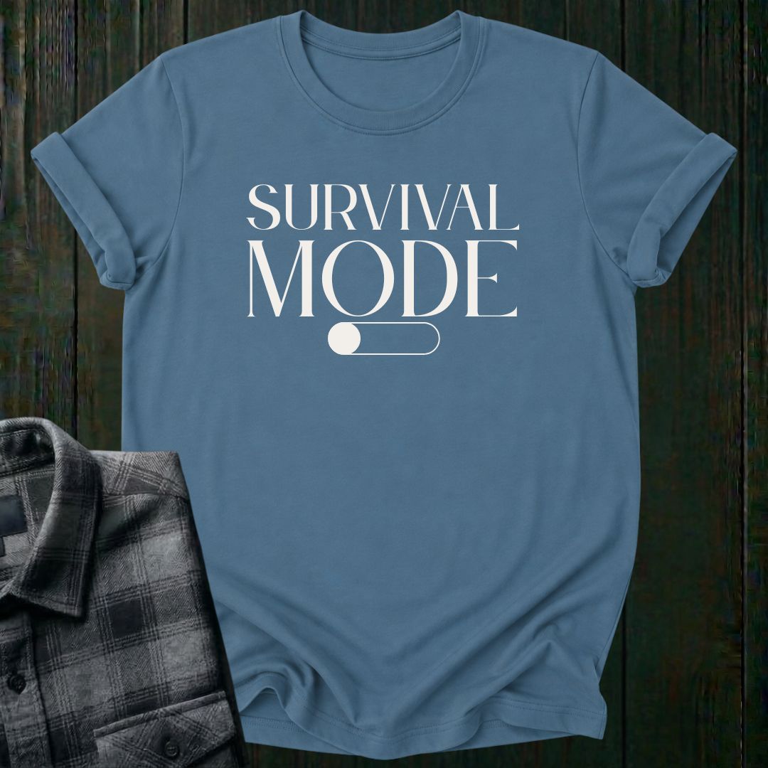 Minimalist typography design featuring the phrase "Survival Mode Off" with a toggle switch graphic in the off position on an indigo blue tee. 