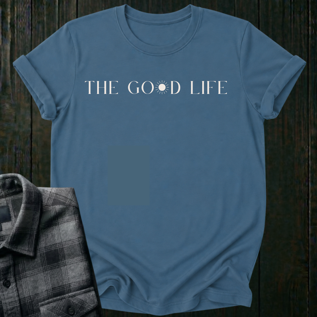 Minimalist typography design featuring the phrase "The Good Life" with a sun replacing the letter O in the word Good on an indigo blue shirt