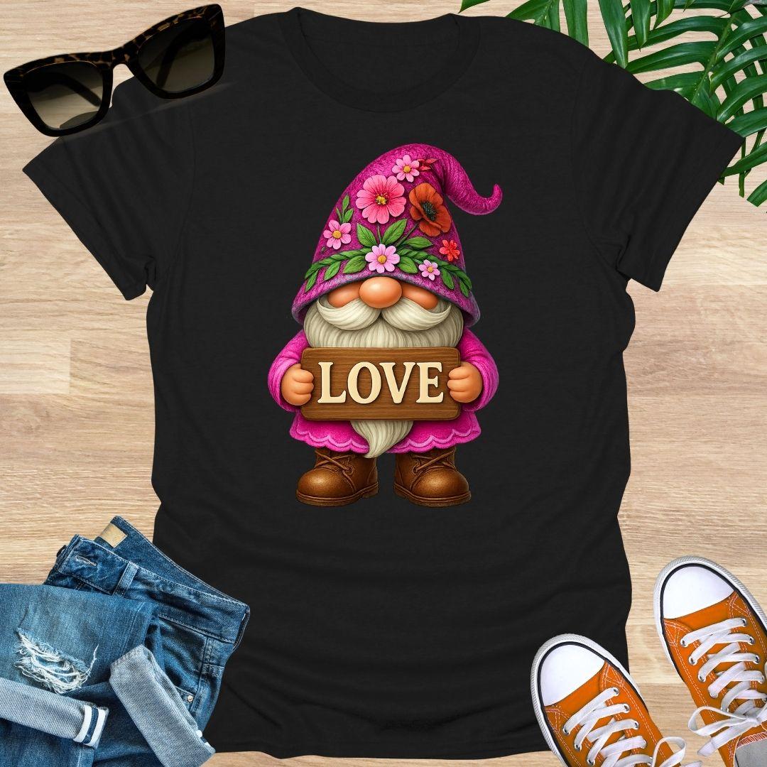 Black t-shirt with a gnome holding a 'LOVE' sign on a wooden surface with sunglasses, jeans, and shoes.