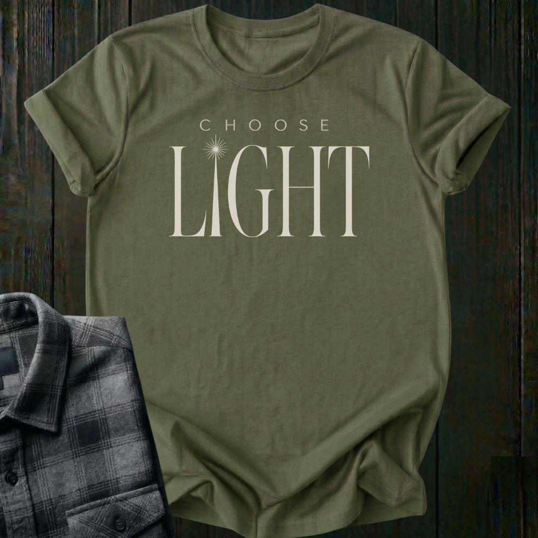 Elegant minimalist typography design featuring the phrase "Choose Light" with a radiant sunbeam replacing the letter I in "Light" on a military green tee