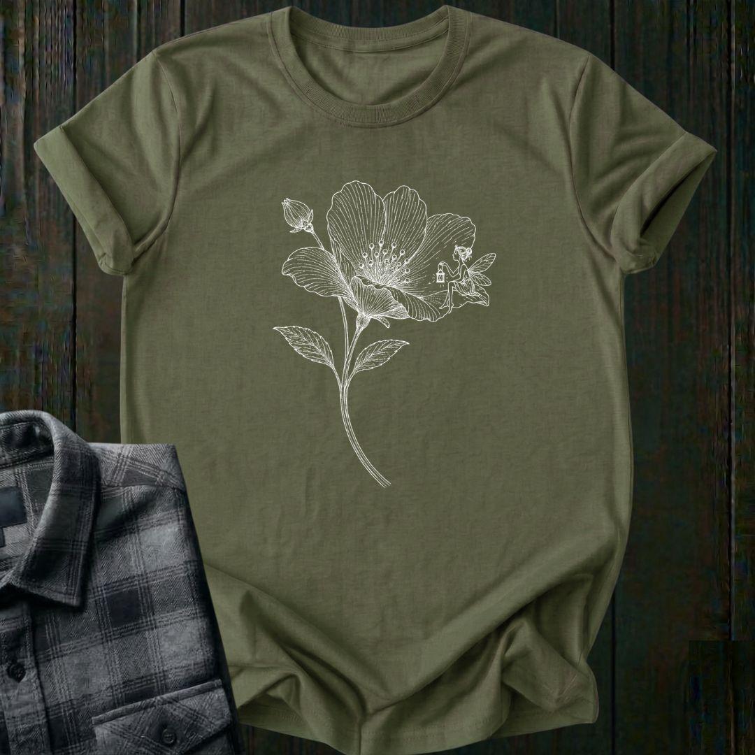 Vintage botanical illustration of a blooming wildflower with a tiny fairy sitting on one petal, surrounded by delicate engraved details and a flower bud on a military tee.
