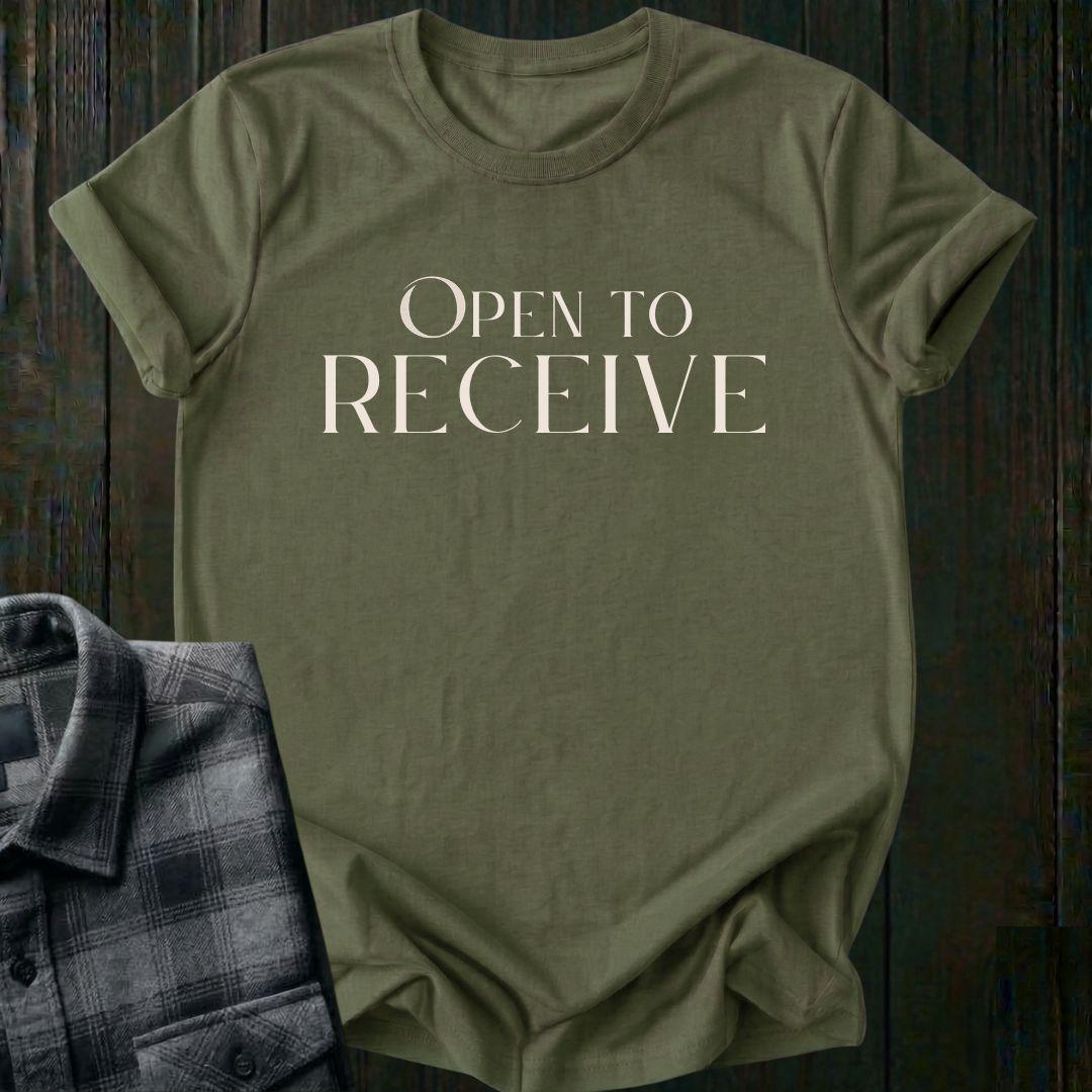 Elegant minimalist typography design featuring the phrase "Open to Receive" in refined serif lettering on a  military green tee