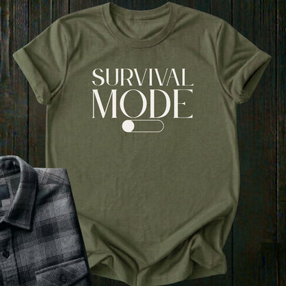 Minimalist typography design featuring the phrase "Survival Mode Off" with a toggle switch graphic in the off position on a military green tee. 