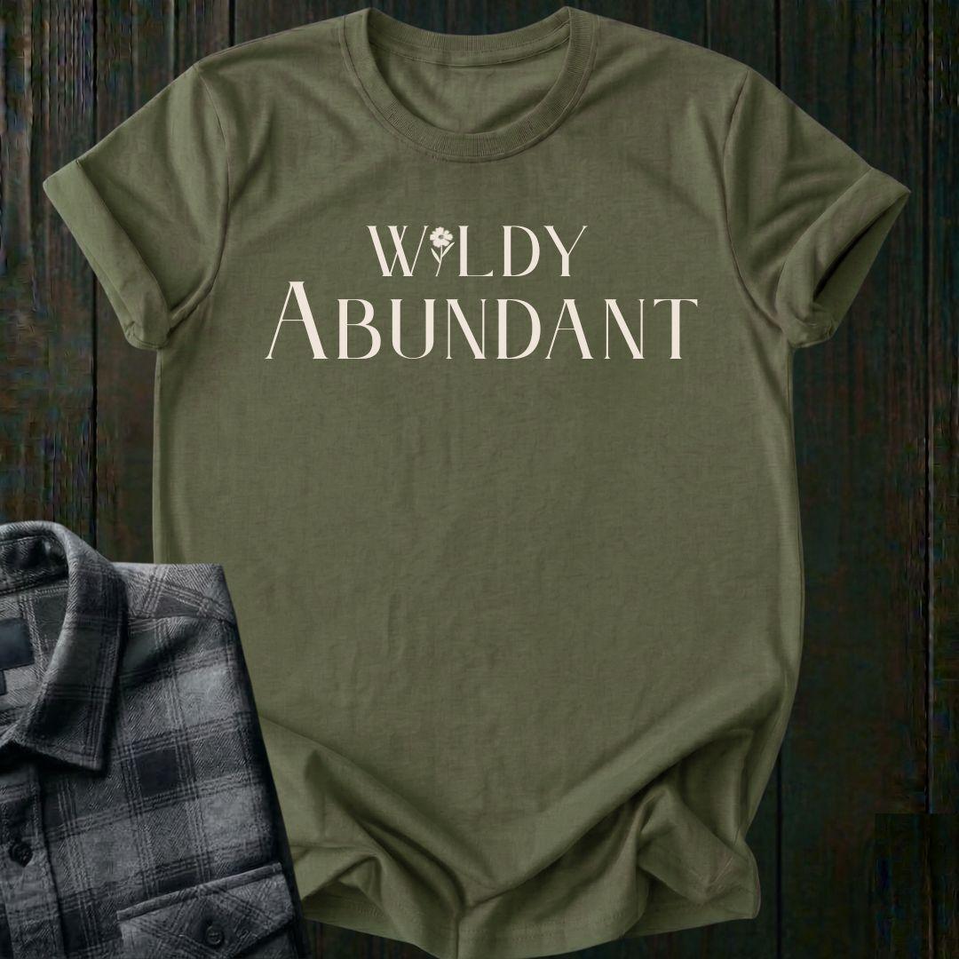Elegant typography design featuring the phrase "Wildly Abundant" with a flower replacing the letter I in Wildly on a military green tee.