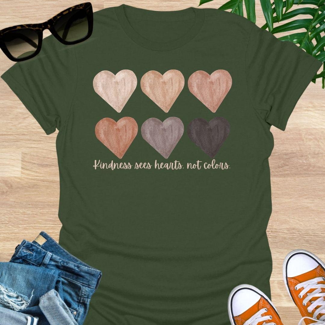 Military Green t-shirt with six watercolor hearts in diverse skin tones above the script “Kindness sees hearts, not colors” on a unisex tee.