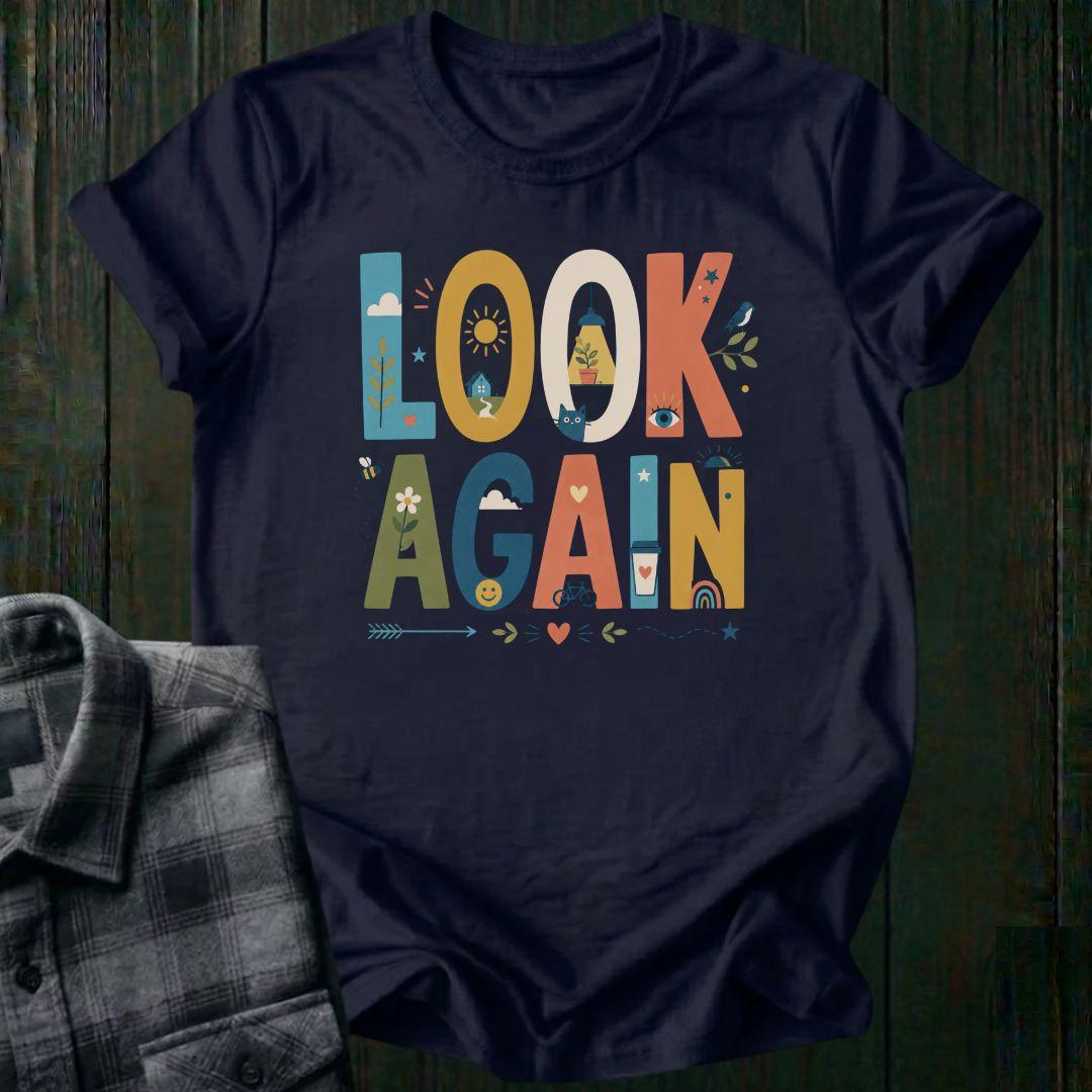 Colorful typography design featuring the phrase "Look Again" filled with cheerful illustrations including a house, sunshine, flowers, coffee cup, bicycle, rainbow, cat, and bird on a navy tee