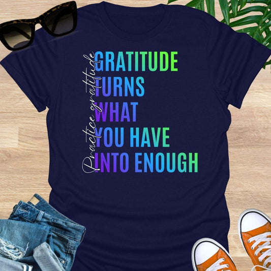 Gradient text tee reading “Gratitude turns what you have into enough” with script “practice gratitude" on a navy unisex tee