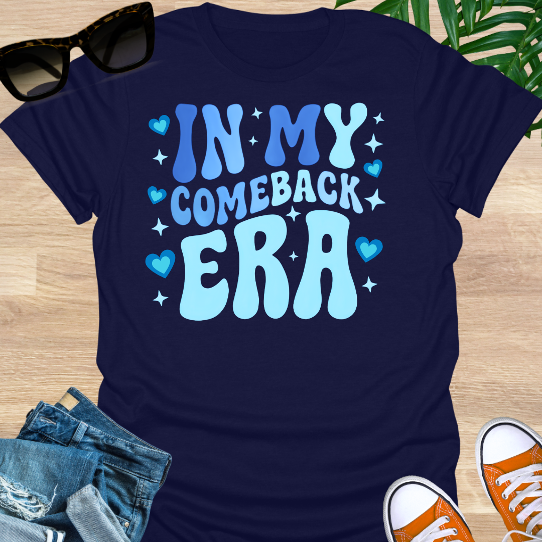 Light-blue groovy text “In My Comeback Era” with hearts and star accents on a navy motivational graphic tee.