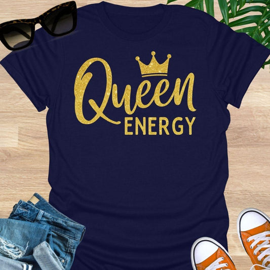 Gold glitter script “Queen Energy” with a crown on a navy empowerment graphic tee.