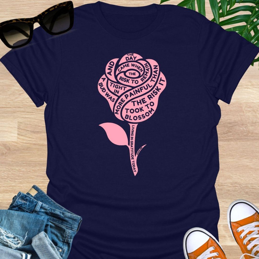 Pink rose with Anaïs Nin “Risk to Blossom” quote on empowerment and growth on navy unisex tee