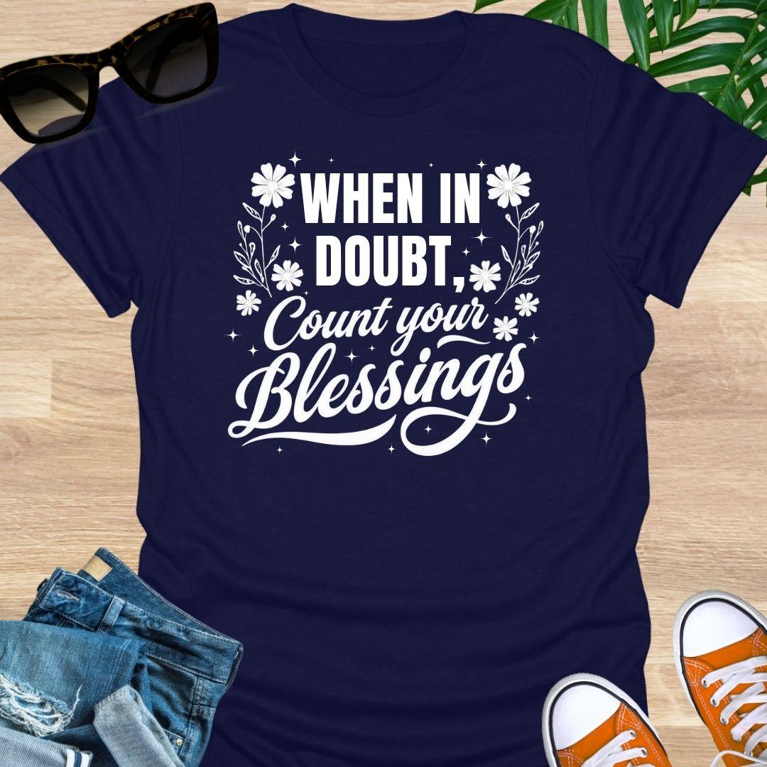 “When in Doubt, Count Your Blessings” in white script with floral and sparkle accents on a navy unisex tee.