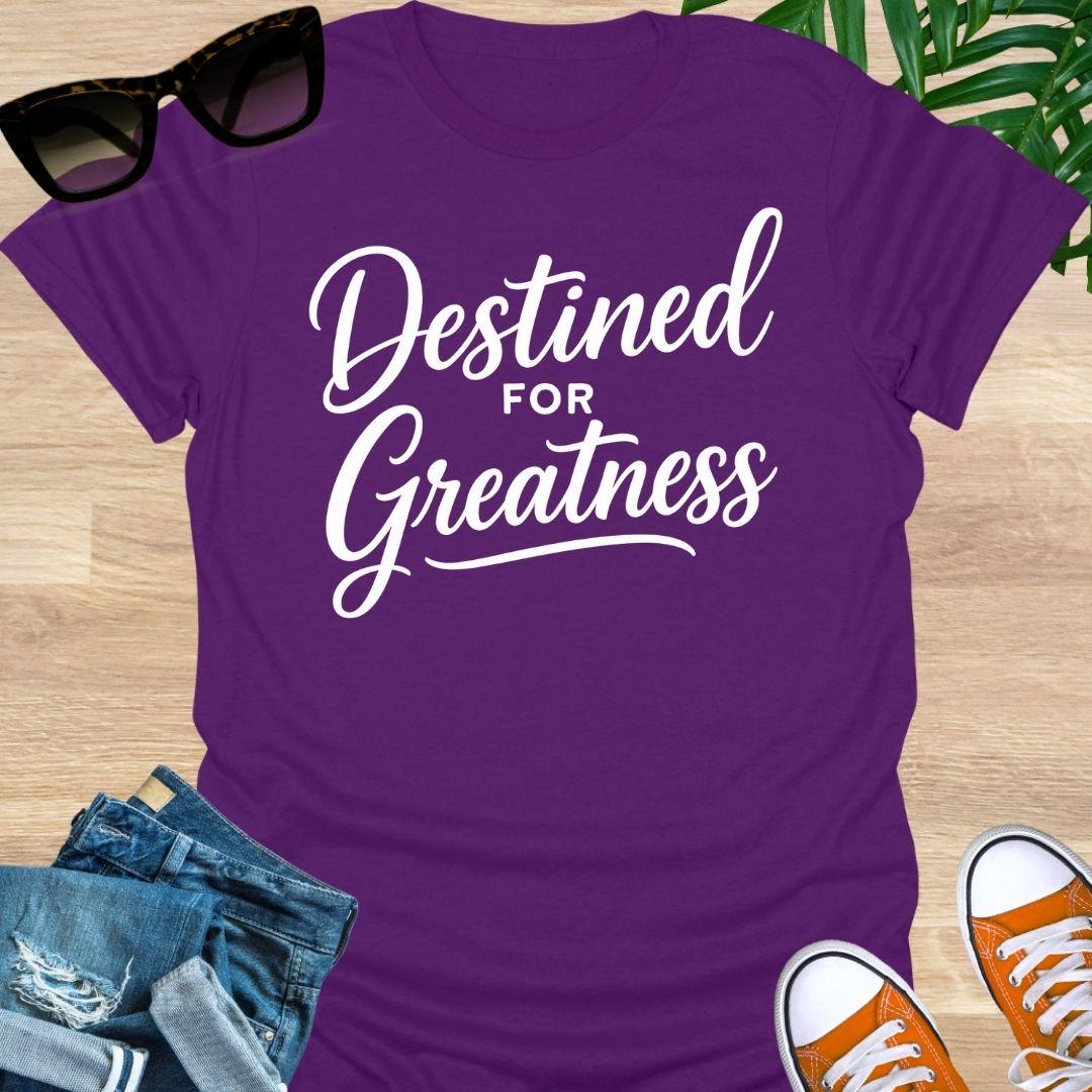 White script text reading “Destined for Greatness” on a purple motivational graphic tee.