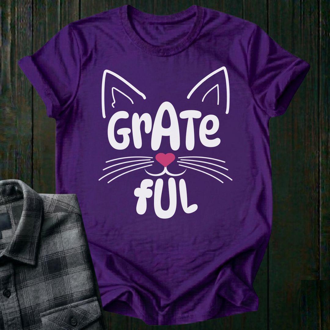 Purple t-shirt with 'Grate Ful' design on a wooden surface
