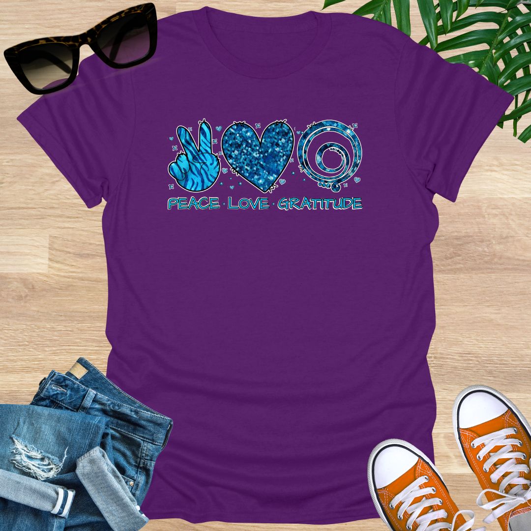 Purple unisex T-shirt with peace sign, heart, and spiral text reading “Peace • Love • Gratitude.”