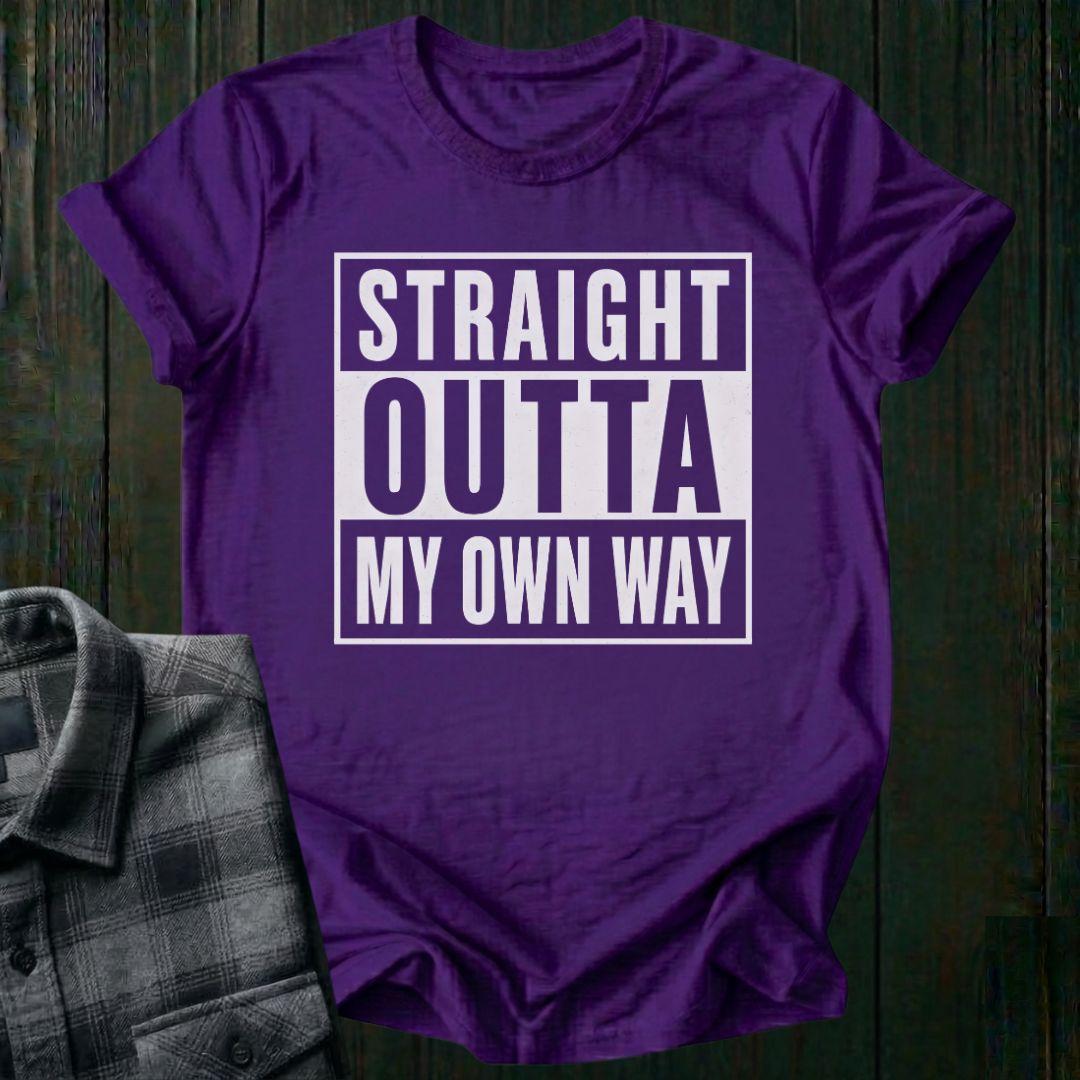 Purple t-shirt with 'Straight Outta My Own Way' text on a wooden surface