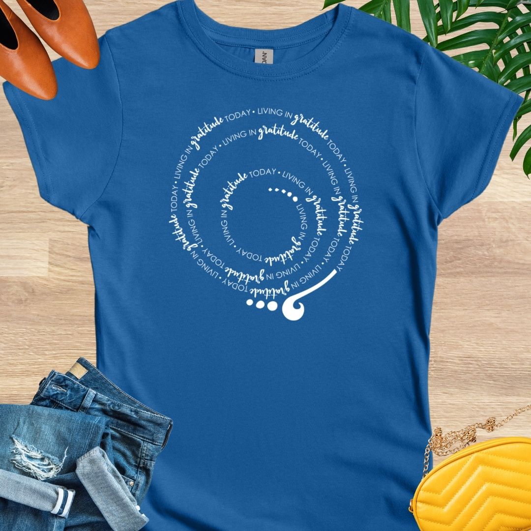 Royal blue T-shirt with a spiral design that repeats "Living in Gratitude Today" in white script. As the spiral gets bigger, so do the letters.  