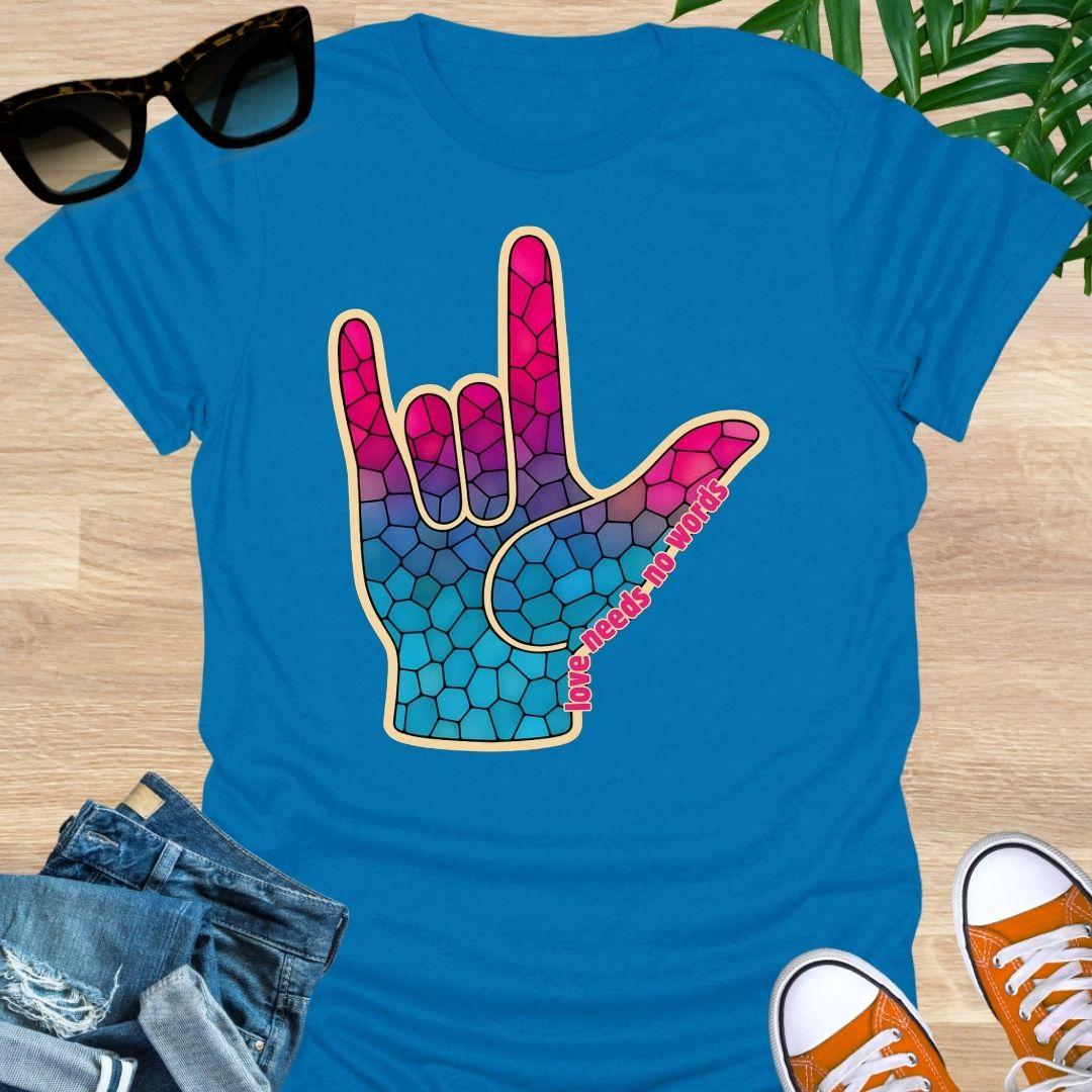 ASL I Love You hand in pink-to-blue mosaic with the words “love needs no words” on a turquoise unisex tee.