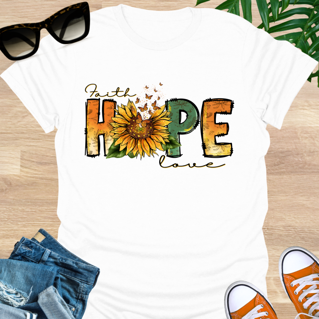 White t-shirt with a sunflower and monarch butterflies between the words "Faith, Hope, Love" on a unisex graphic tee.